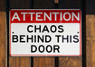 a red and white sign on a wooden fence