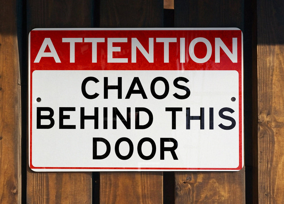 a red and white sign on a wooden fence
