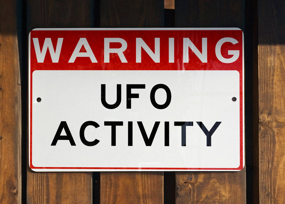 a red and white sign that is on a wooden fence