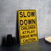 a yellow slow down sign sitting on top of a table