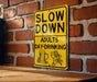 a yellow slow down sign on a brick wall