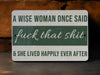 a sign that says a wise woman once said fuck that shit and she lived happily