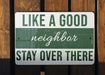 a green and white sign that says like a good neighbor stay over there