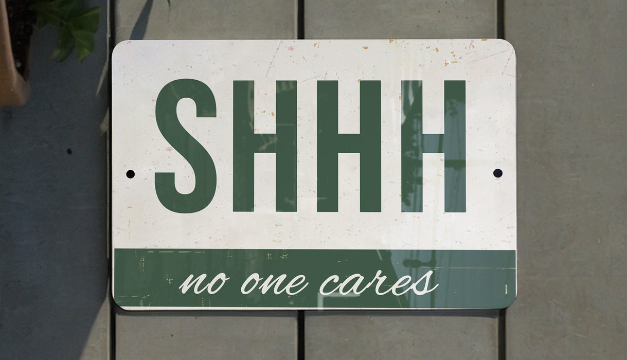a green and white sign that says shh no one cares