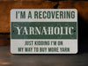 a green and white sign that says i'm a recovering yarnaholic