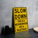 a yellow slow down sign sitting on top of a table