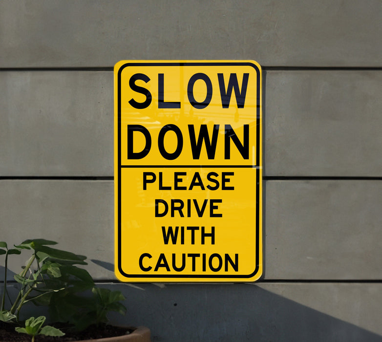 a yellow slow down sign next to a potted plant