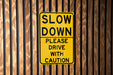 a yellow slow down sign on a wooden wall
