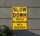 a yellow slow down sign on the side of a building