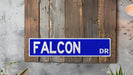 a blue street sign mounted to the side of a wooden wall