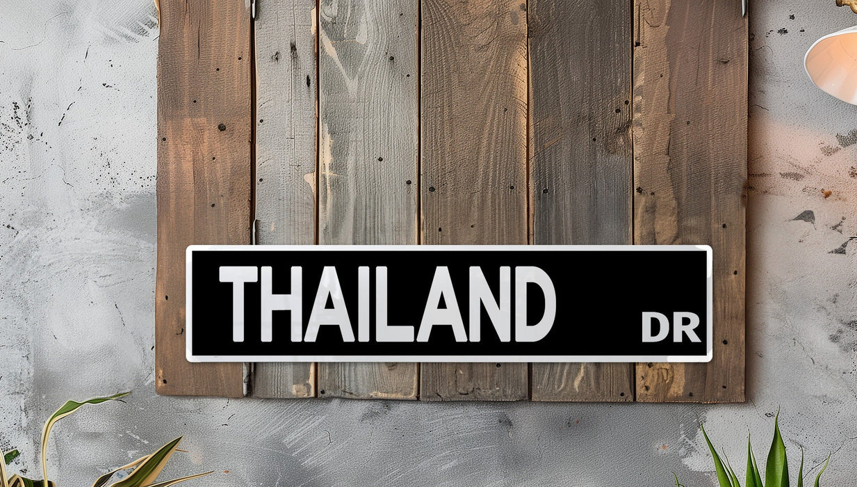 a black and white street sign mounted to a wooden wall