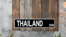 a black and white street sign mounted to a wooden wall