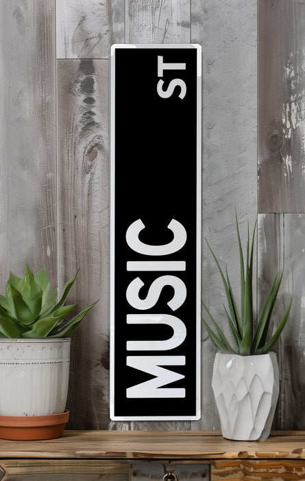 a black and white sign sitting on top of a wooden shelf
