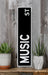 a black and white sign sitting on top of a wooden shelf