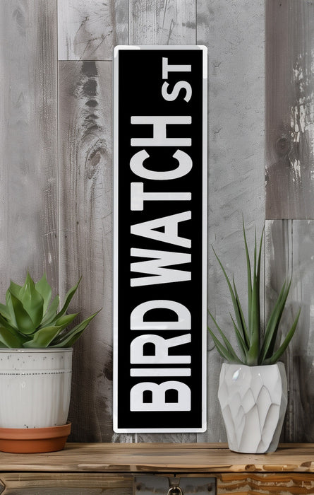 a black and white sign sitting on top of a wooden shelf