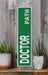 a green door sign sitting on top of a wooden shelf