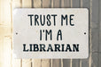 a white sign that says trust me i'm a librarian