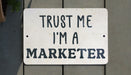 a sign that says trust me i'm a marketer
