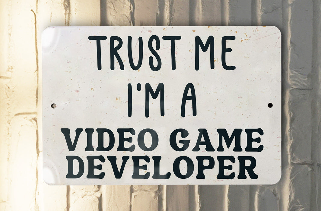a white sign that says trust me i'm a video game developer