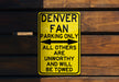 a yellow sign on a wooden wall that says denver fan parking only all others are