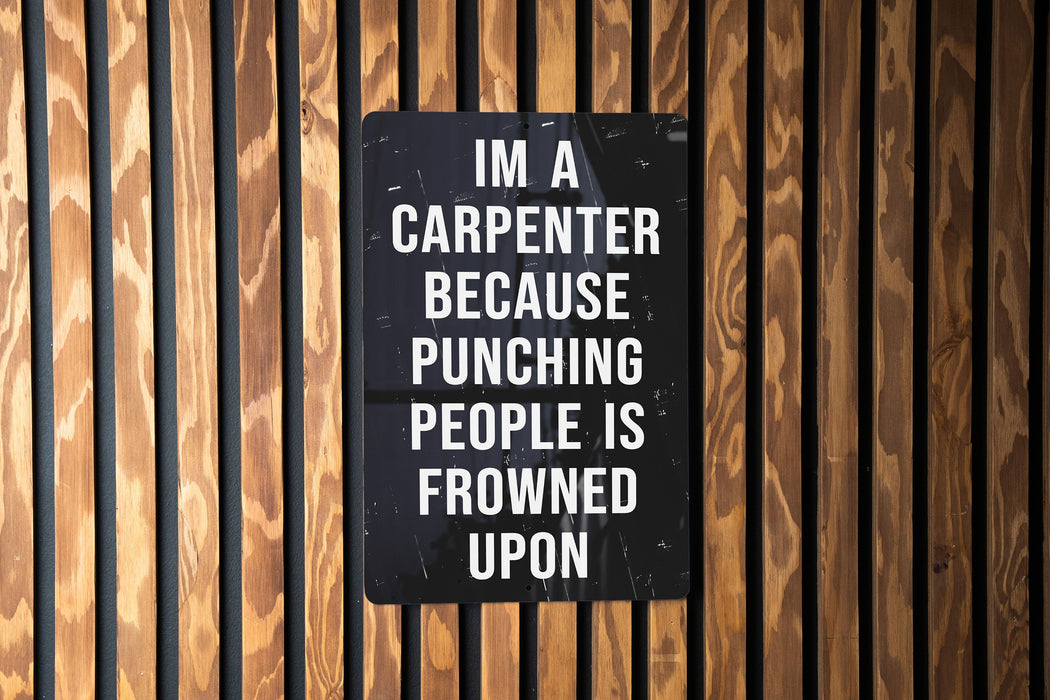 a sign on a wooden wall that says i'm a carpenter because punching people