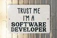 a white sign that says trust me i'm a software developer