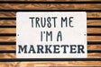 a sign that says trust me i'm a marketer