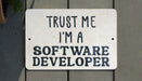a white sign that says trust me i'm a software developer