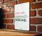 a sign on a brick wall that says never enough hiking