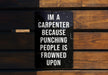 a sign on a wooden bench that says i'm a carpenter because punching people