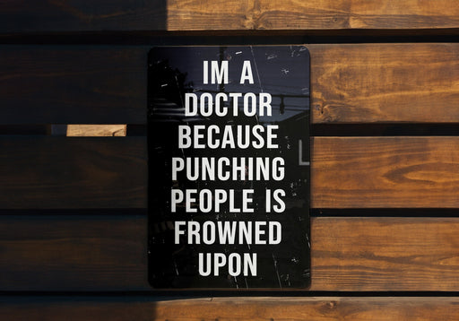 a sign on a wooden bench that says i'm a doctor because punching people