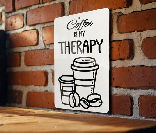 a sign on a brick wall that says coffee is my therapy