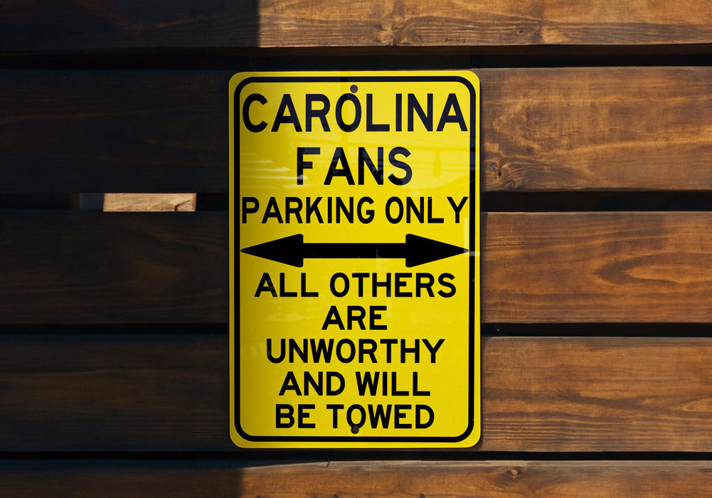 a yellow parking only sign hanging on a wooden wall