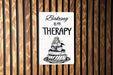 a sign on a wooden wall that says baking is my therapy