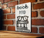 a book nerd sign on a brick wall