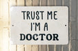 a white sign that says trust me i'm a doctor