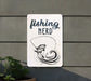 a sign that says fishing nerd next to a potted plant