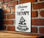 a sign on a brick wall that says baking is my therapy