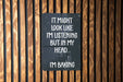 a sign that says it might look like i'm listening but in my head