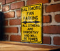 a yellow sign on a brick wall that says baltimore fan parking all others are un