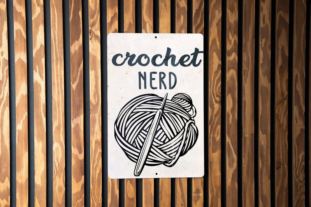 a sign on a wooden wall that says crochet nerd