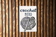 a sign on a wooden wall that says crochet nerd
