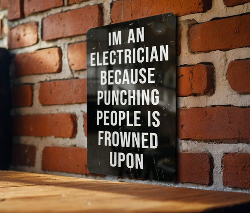 a sign on a brick wall that says i'm an electrician because punching