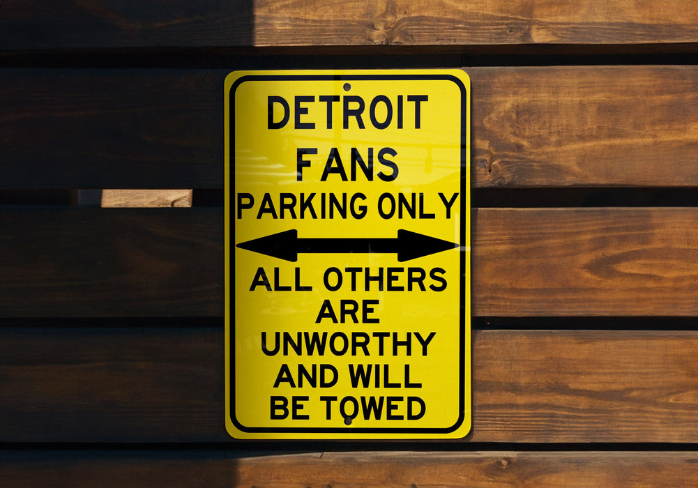 a yellow sign on a wooden wall that says detroit fans parking only all others are