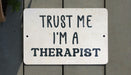 a white sign that says trust me i'm a therapist