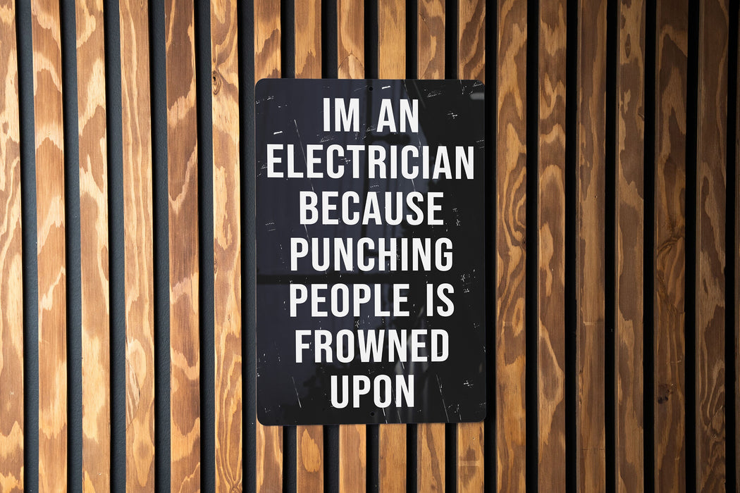 a sign on a wooden wall that says i'm an electrician because punching