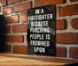 a sign on a brick wall that says i'm a firefighter because punching