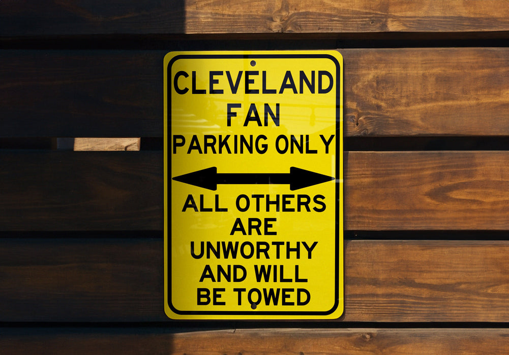 a yellow parking only sign on a wooden wall
