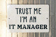 a white sign that says trust me i'm an it manager