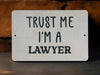 a white sign that says trust me i'm a lawyer